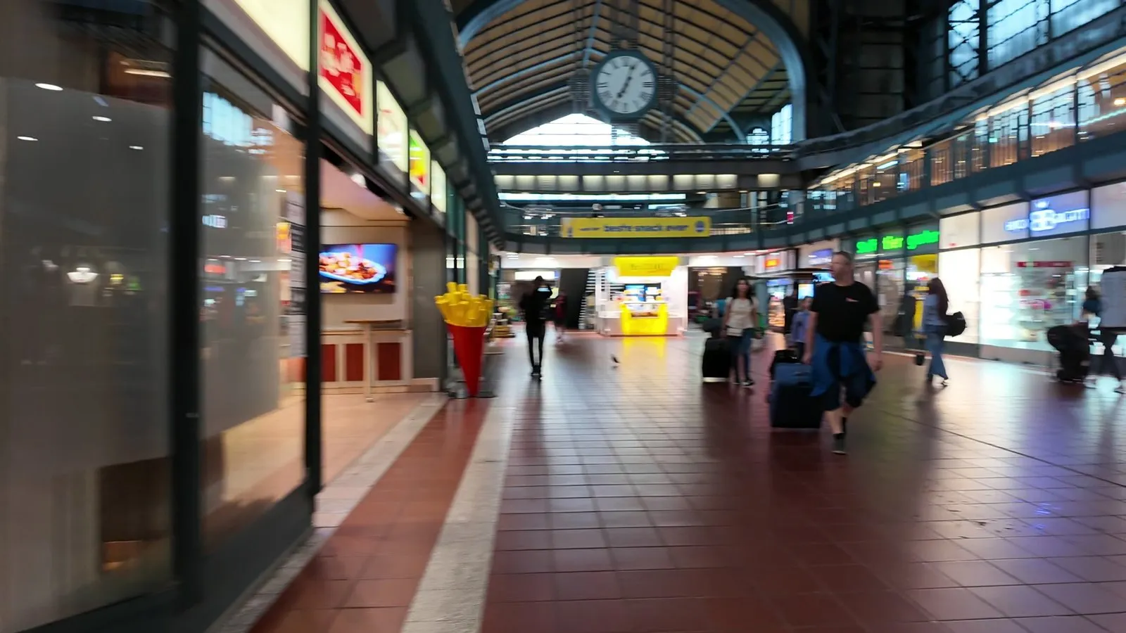 ハンブルク中央駅の構内。大きな時計の下に店が並び、2階の回廊がホールを囲んでいる