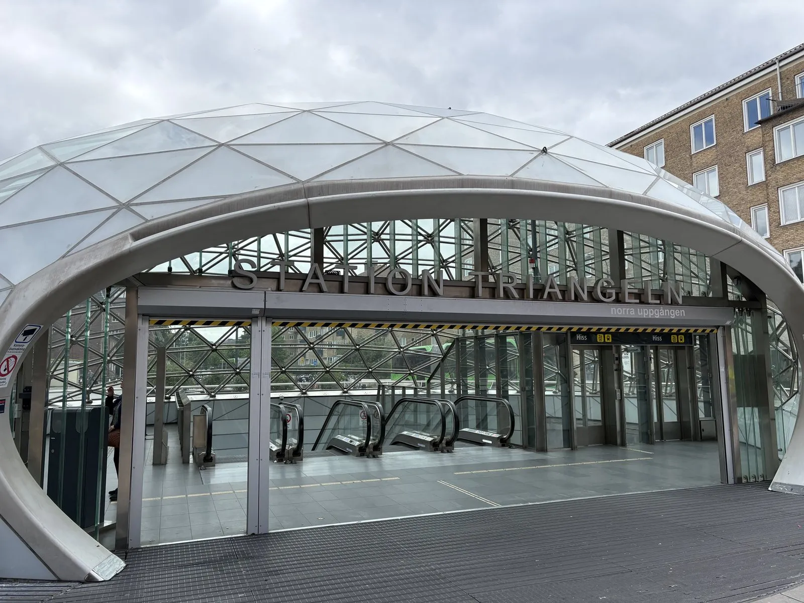 マルメのトリアンゲルン駅の入口。ガラスのドームの下に、地下へ降りるエスカレーターが並ぶ