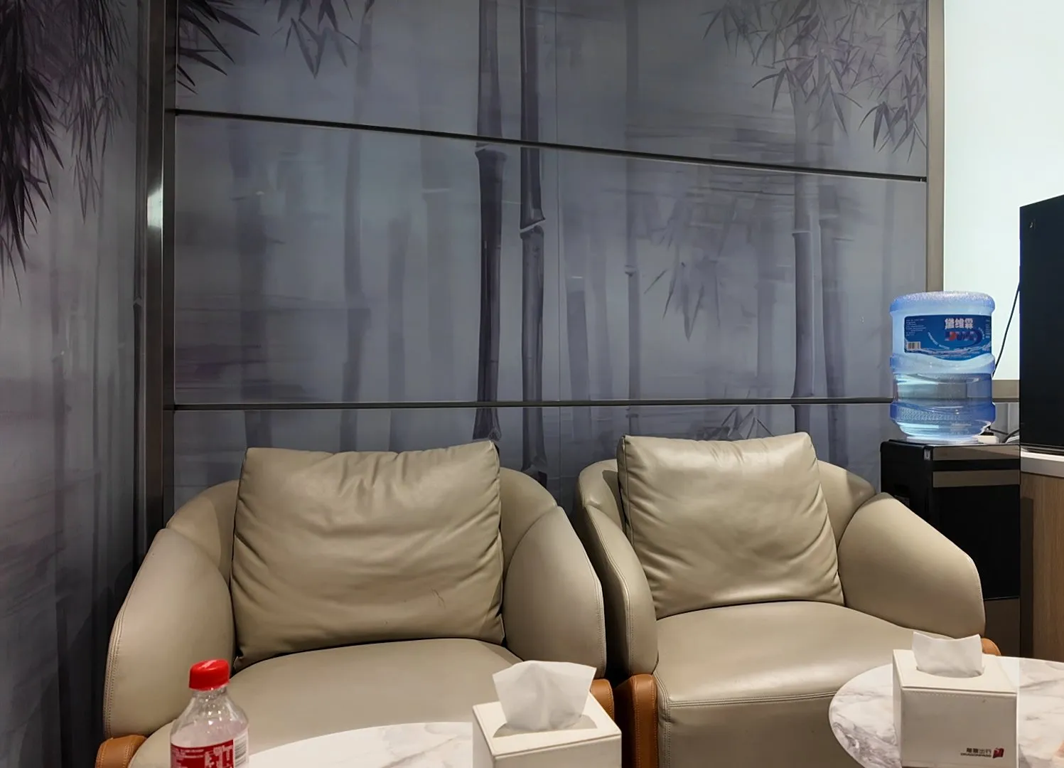 北京の空港のラウンジ。竹の絵の壁の前に、ひとりがけのソファが並ぶ